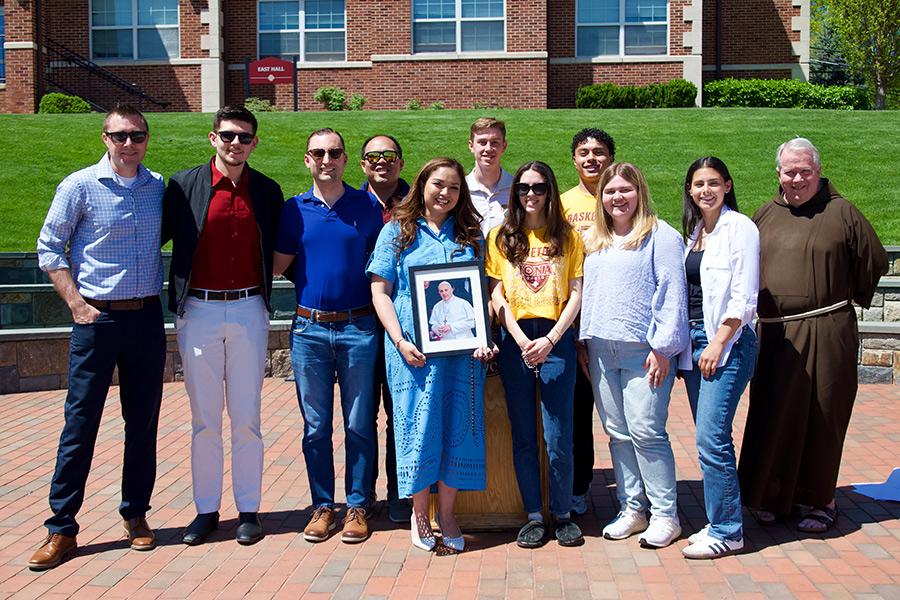 Students and staff on the Murphy Green with a photo of the Pope.