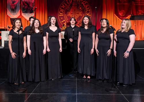 Isabella Ruggiero and group, on stage singing during a event.