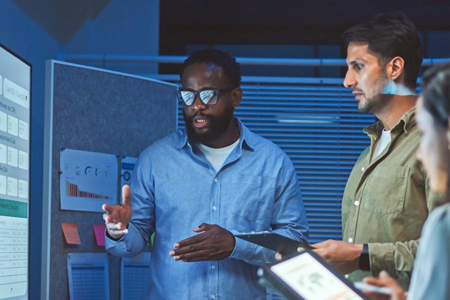 Employees review data using AI in an office.