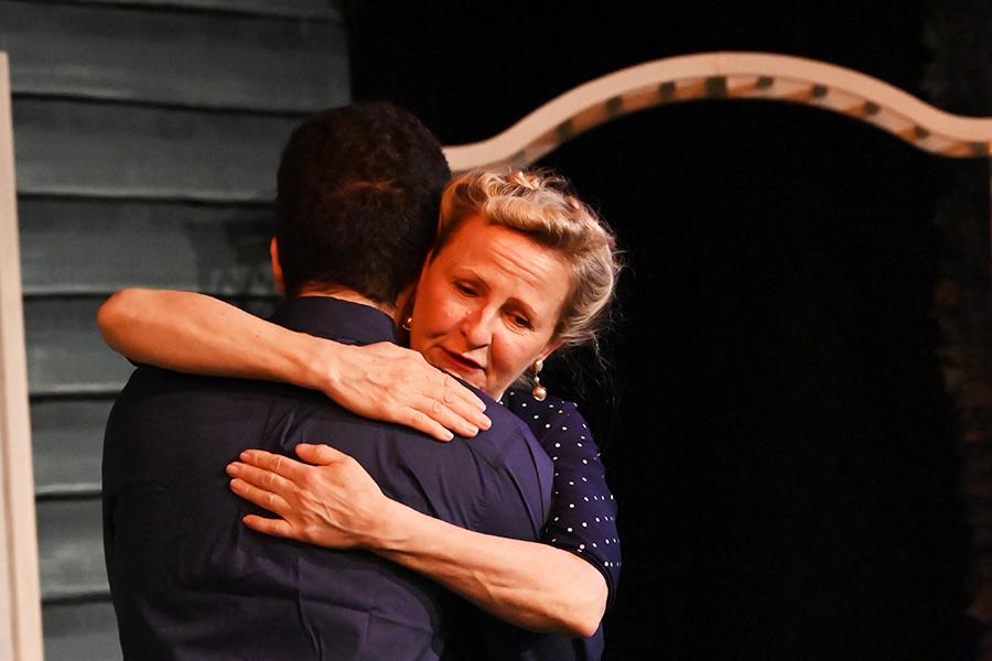 A woman hugs a man in farewell.