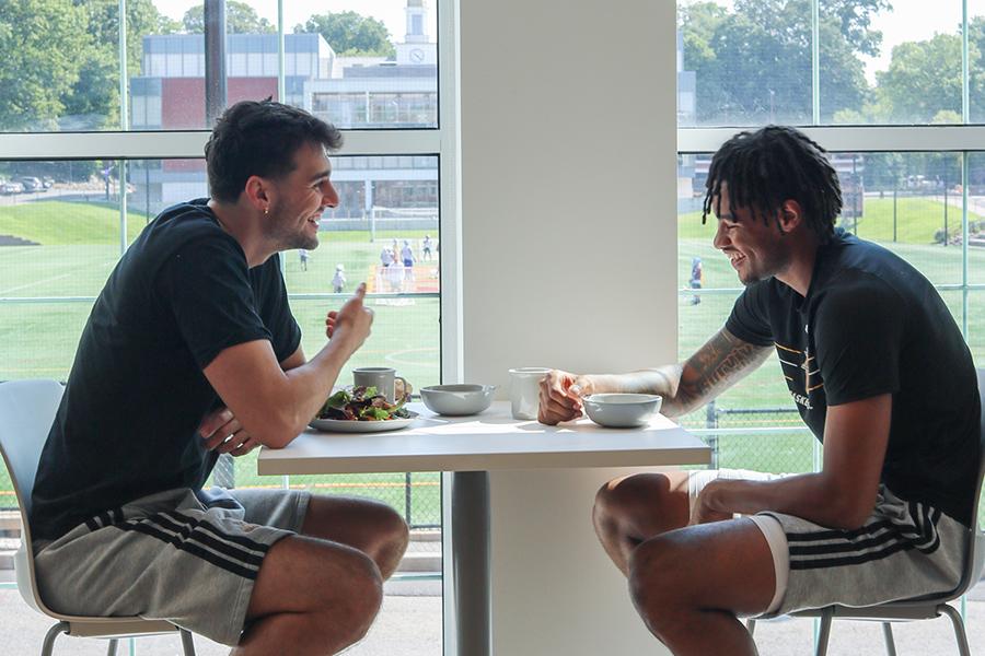 Two basketball players enjoy lunch in the new dining hall.