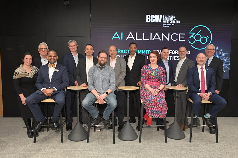 A group of thirteen speakers and organizers from the AI Alliance 360° Impact Summit pose for a photo, with Iona University’s Rob Kissner seated front and center.