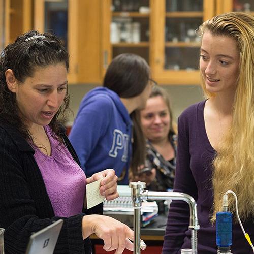 A professor works with a student in the biology lab.