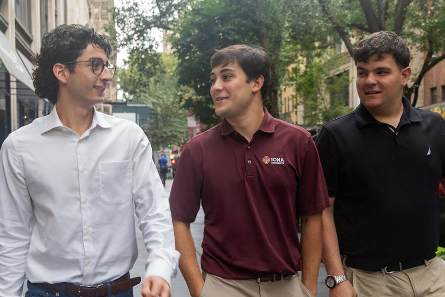 Three business students walk down the street in New York City.