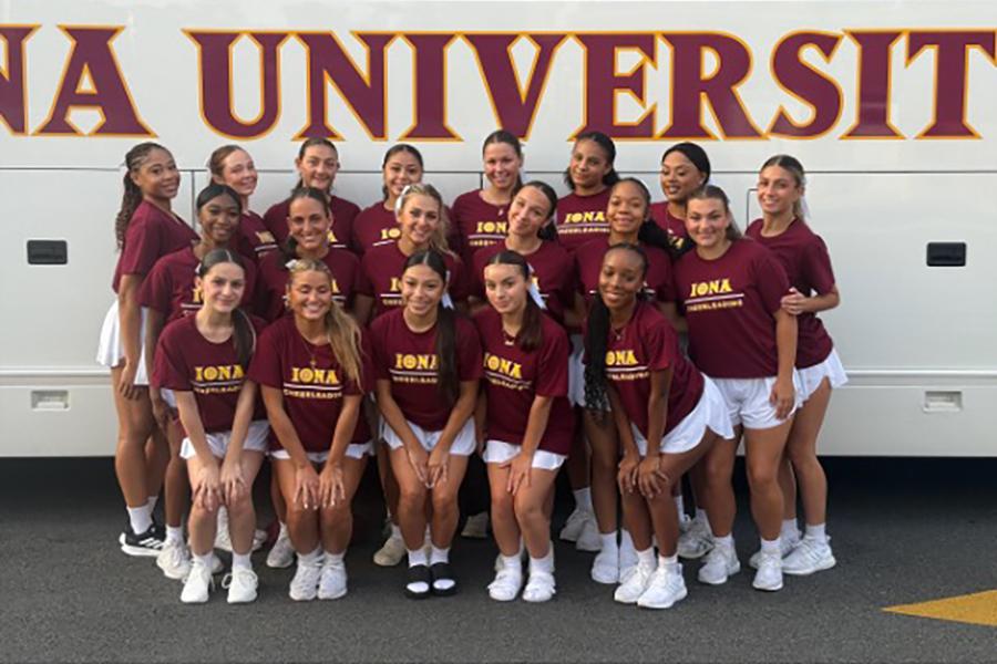 Iona Cheerleading Team group photo posing and smiling in front Iona University bus.