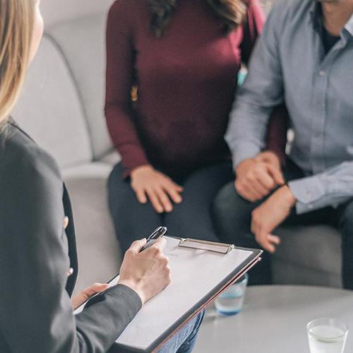 An MFT takes notes during a session.