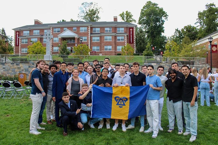 Members of Delta Upsilon on the Murphy Green with their flag.