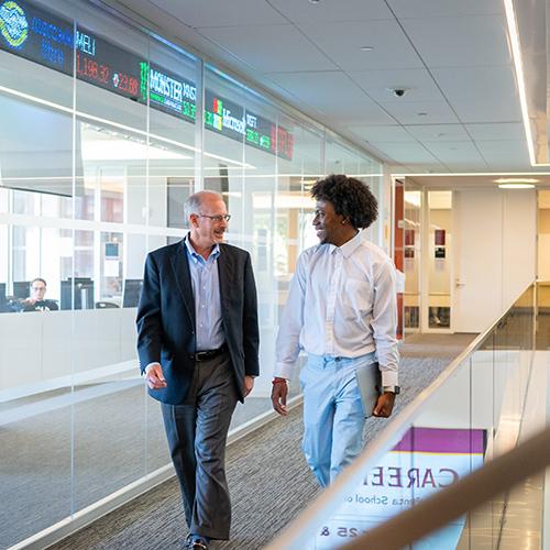 John DeMelis walking with a student.