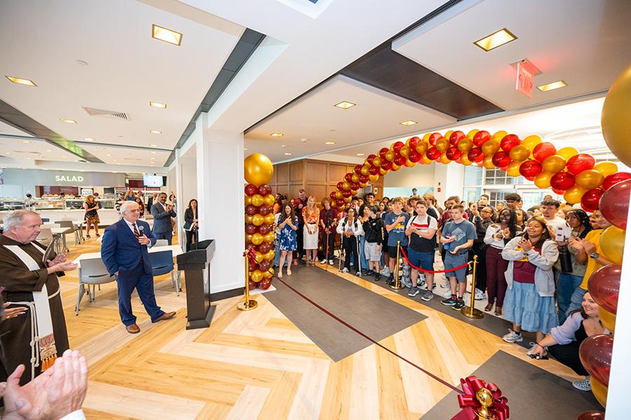 The dining hall ribbon cutting with a balloon arch.