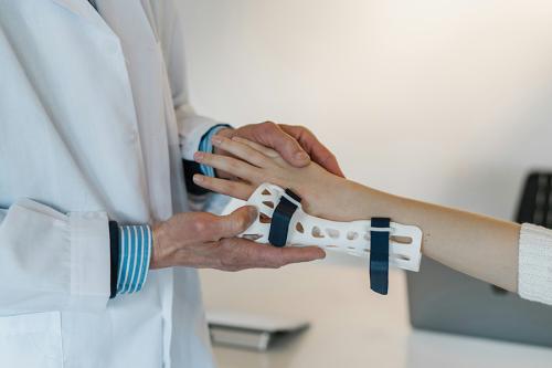 A doctor puts a wrist brace on a patient.