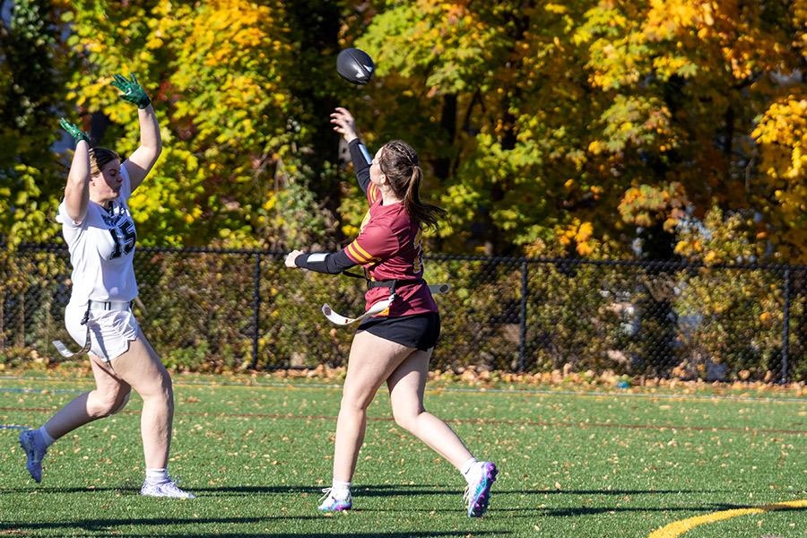 Iona University's Women's Club Flag Football player throwing the football to teammate during a game.