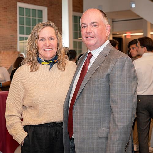 Two alumni smiling and posing for a picture at the Gaels Go Further 5 Year Anniversary.