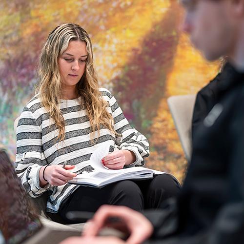 A graduate student studies from a textbook.