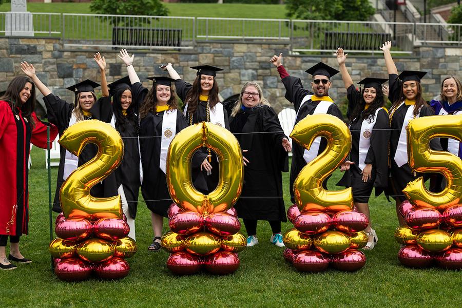 Grads in front of the 2025 balloons on campus.