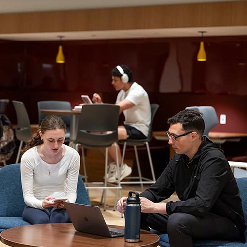 Two graduate students study together in the lounge.