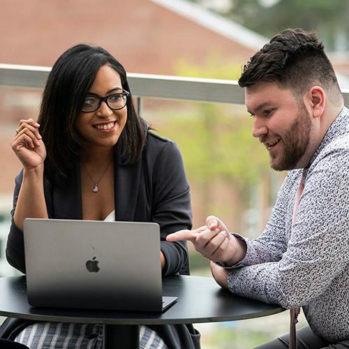 Health care business students study on the terrace of LSB.