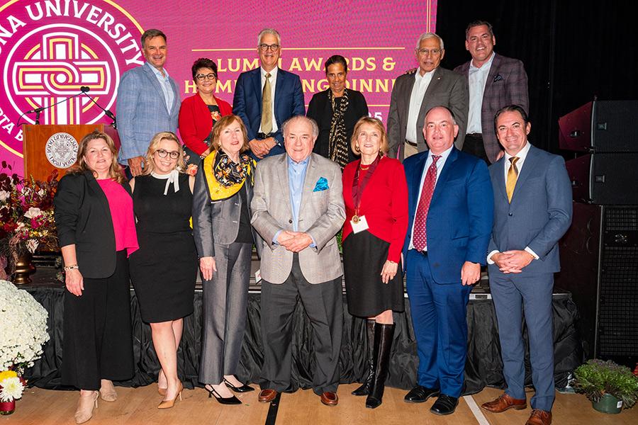 Iona alumni and faculty smiling and posing for a group photo at the Iona University’s Alumni Awards & Homecoming Dinner.