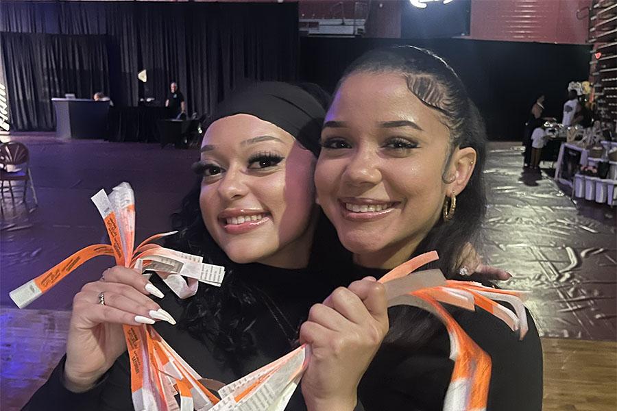 Two members of Phi Gamma Chi hold tickets at a party.