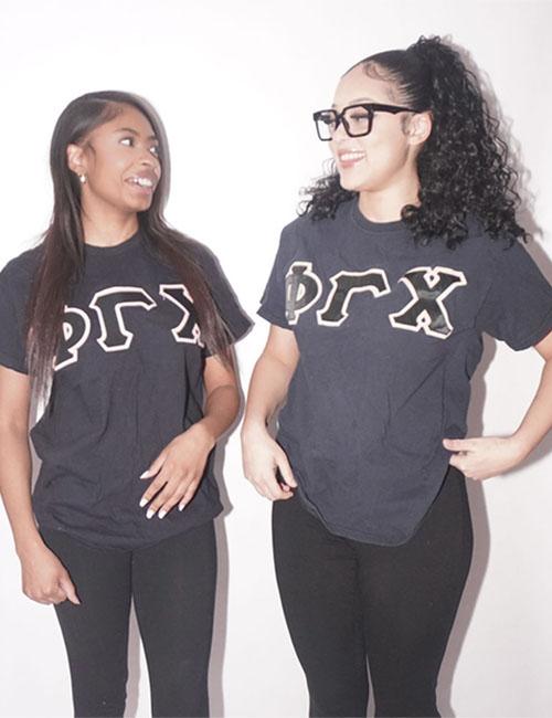 Two members of Phi Gamma Chi in sorority shirts.
