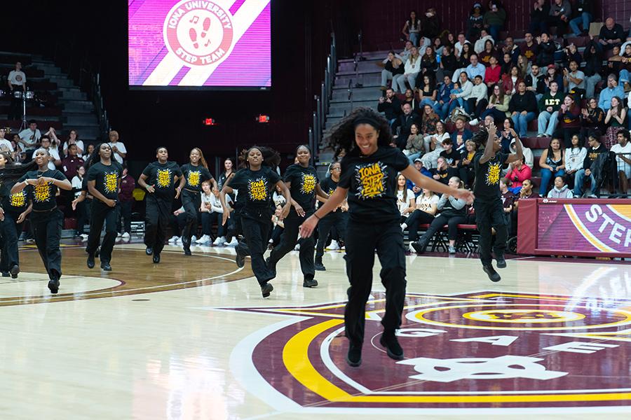 The Step Team performs at half time and a member smiles with joy.