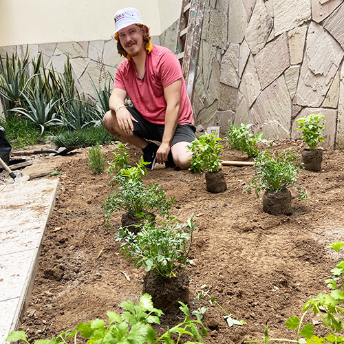 An Iona student volunteers in the garden.