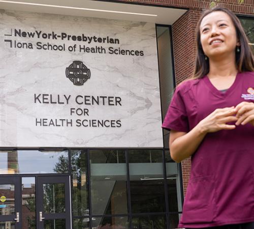 An Iona OT student in front of the Kelly Center.