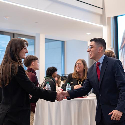 Johnny Hernandez shaking hands and networking at the Mastercard event.