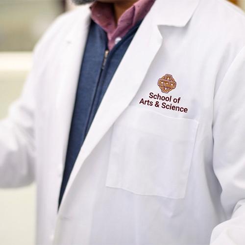 A School of Arts & Science student in a white lab coat.