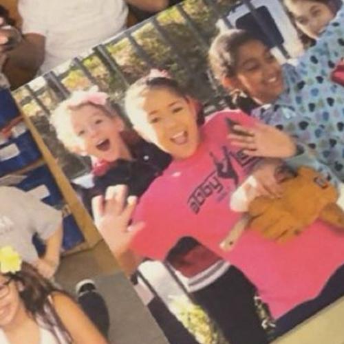 A printed photo of Lelia and Grace waving as children.