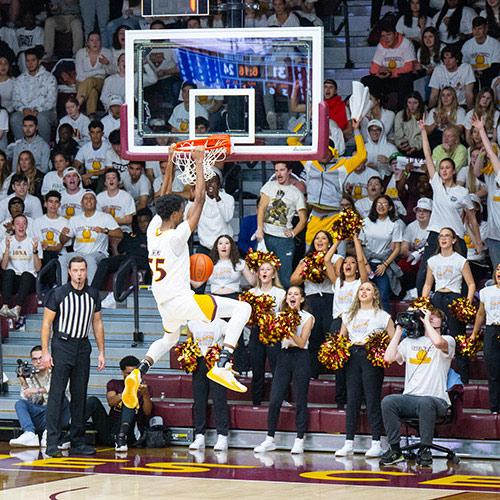 A player dunks at a basketball game.