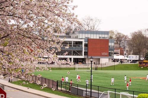 A view of the LaPenta School of Business through the cherry trees in blossom.