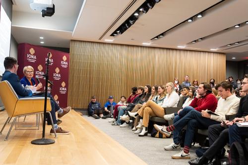 Maggie Timoney on stage with the audience in their seats.