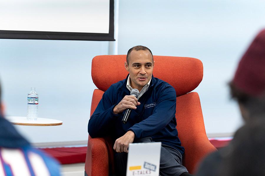 Matt Rizzetta speaking into a microphone at a talk at Hynes Institute.