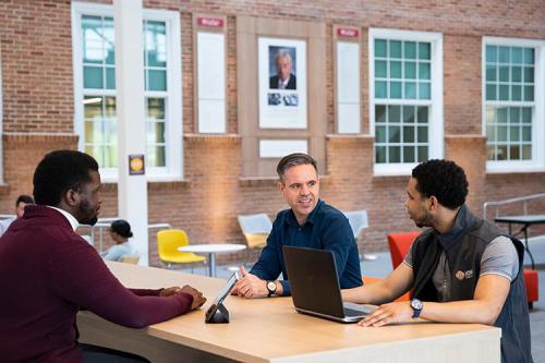Three students work together in the atrium of LSB.