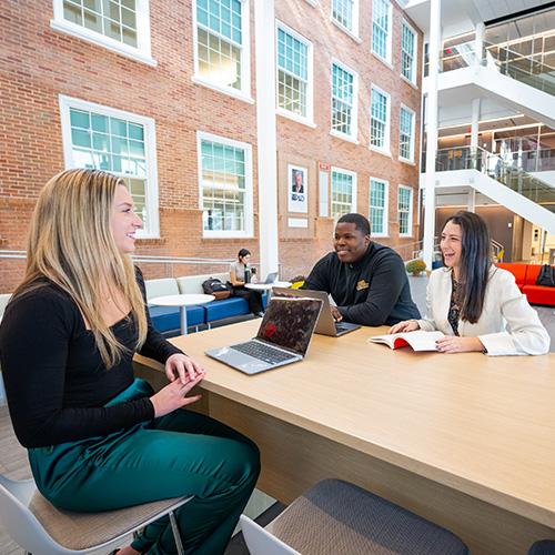 Three MBA students study together in the LSB atrium.