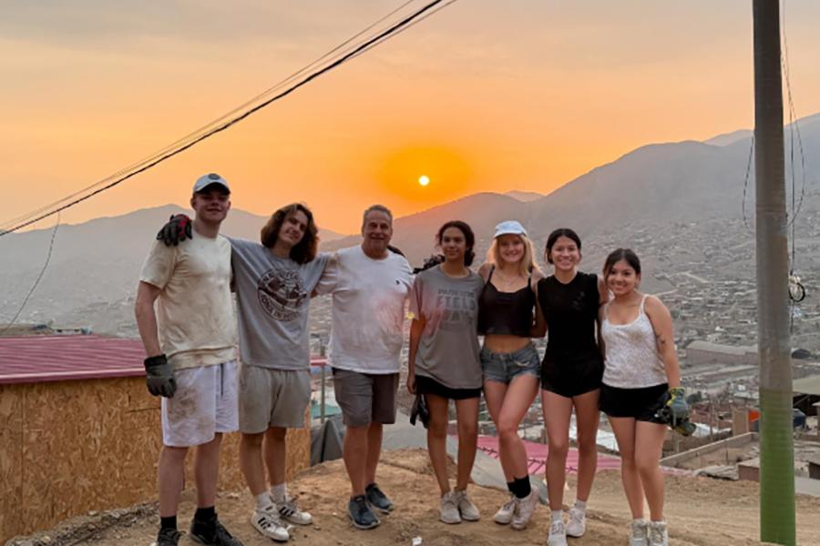 The Iona students with Professor Jarmon, taking a group photo with the sun setting in the background after a hard days work.