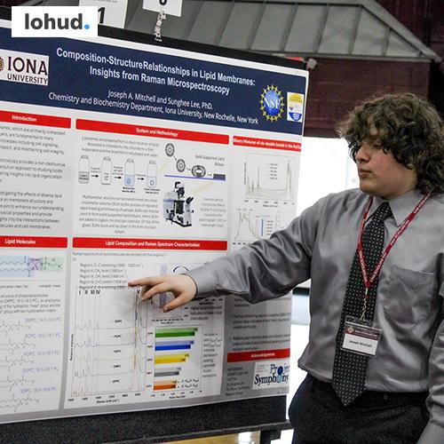 An NSF student presents at Iona Scholars Day with the Lohud logo in the corner.