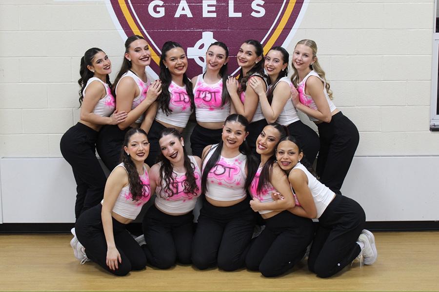 Dance Team Members taking a group photo in front of the Gaels logo inside the Mulcahy Gymnasium.