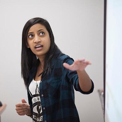 A math professor teaches at a whiteboard.