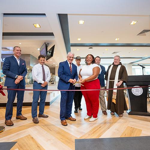 Members of campus leadership cut the ribbon in the dining hall.