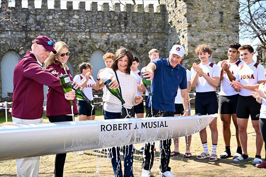 Robert Musial and others pour champagne to christen a boat.