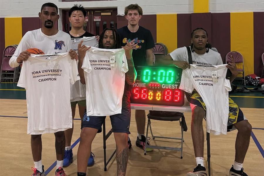 The intramural basketball team holds up their t-shirts.