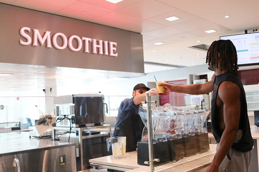 A student getting a smoothie in the dining hall.