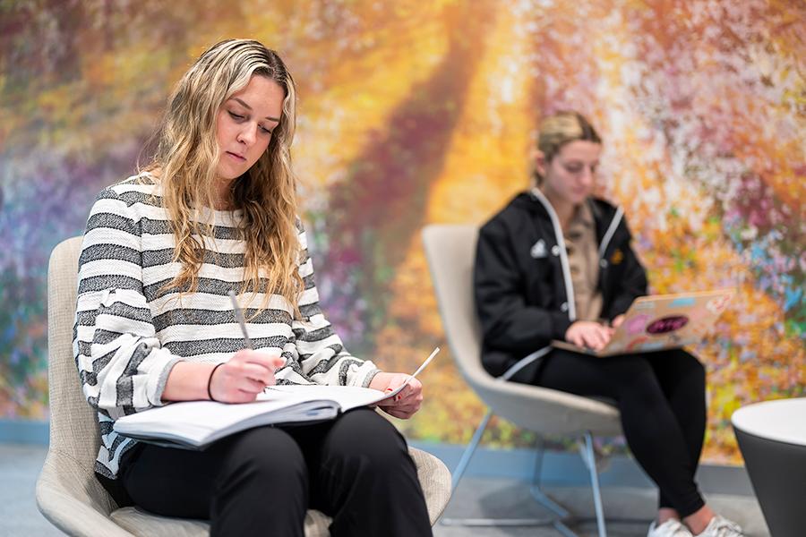 Two sociology students take notes.