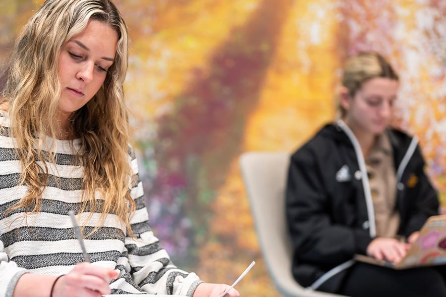 Two sociology students take notes.