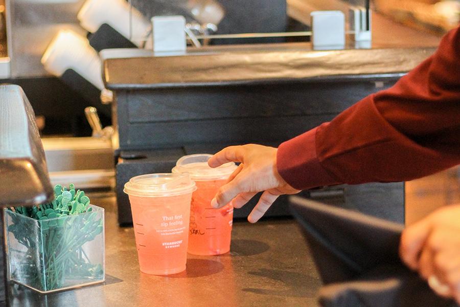 A graduating student reaches for a chilled drink from Starbucks.