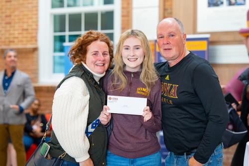 A student and her parents show her acceptance letter.