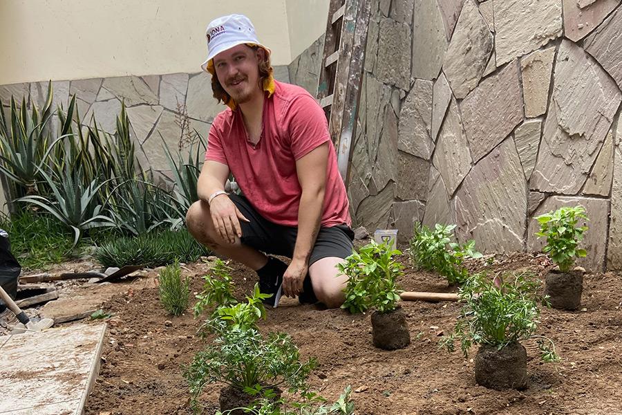 A student volunteers in a community garden.