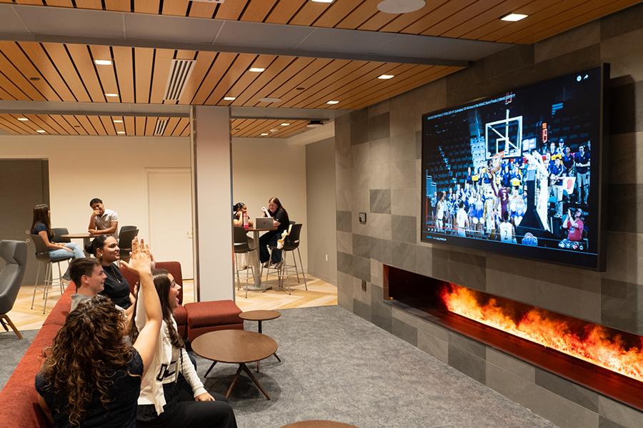 Students watch a basketball game in the student lounge.