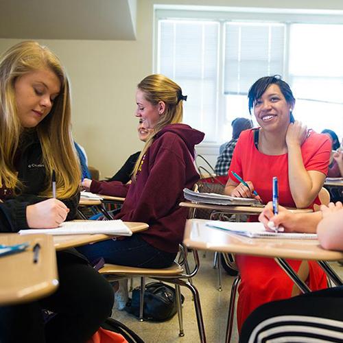A student working in a group smiles during class.